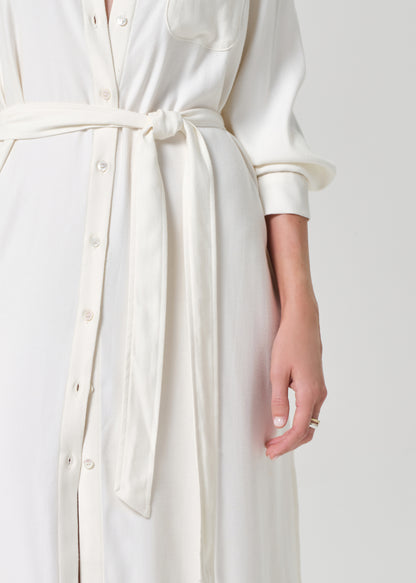 Person wearing a long white dress on a grey background