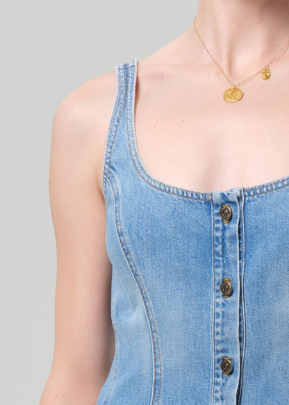 Woman wearing a blue denim dress on a plain background