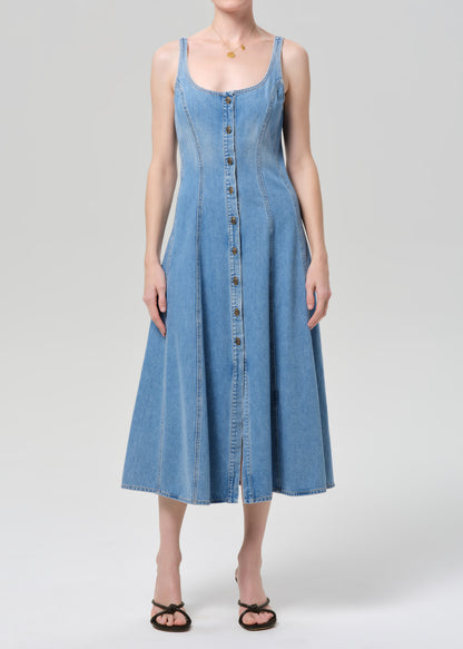 Woman wearing a blue denim dress on a plain background