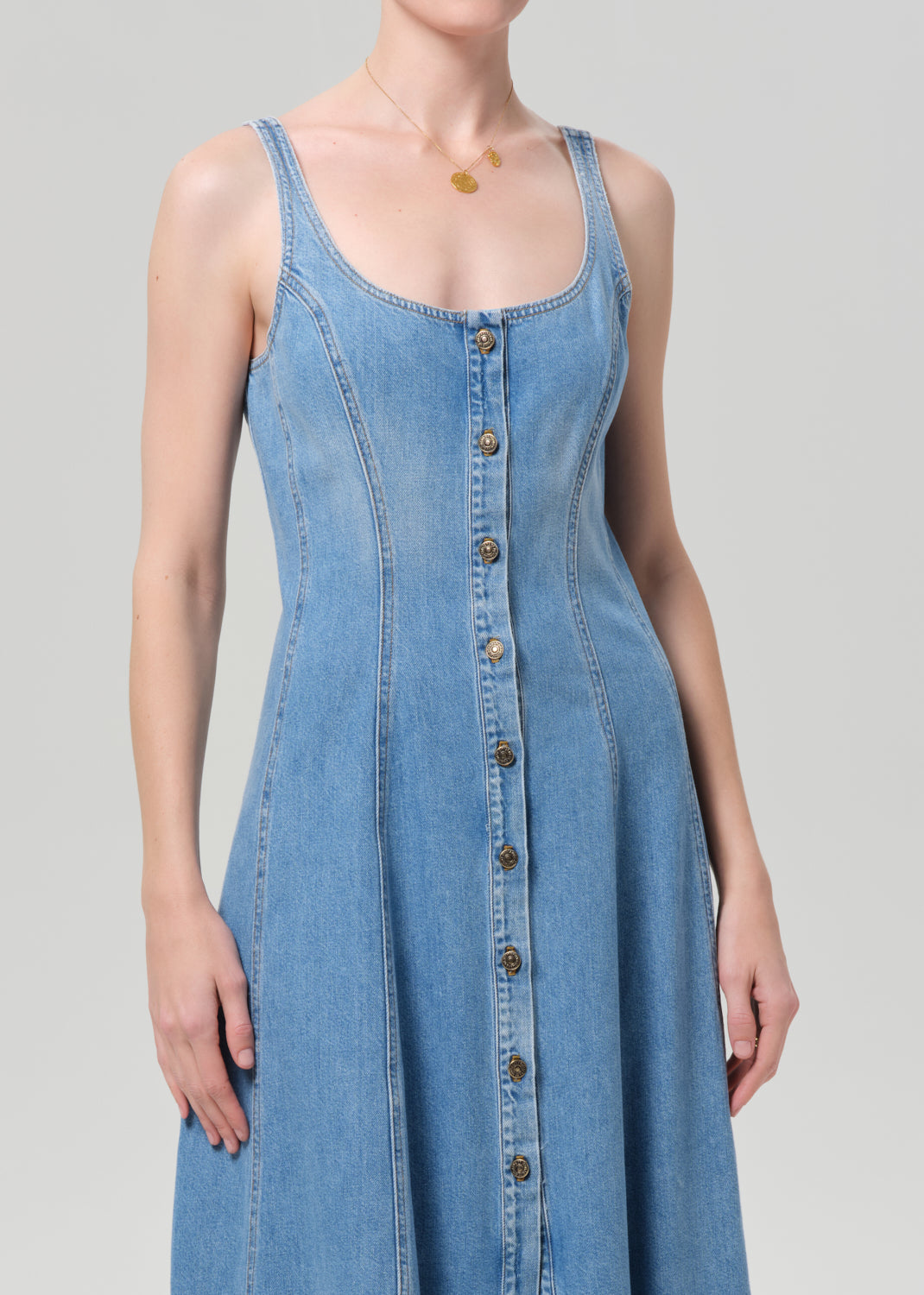 Woman wearing a blue denim dress on a plain background