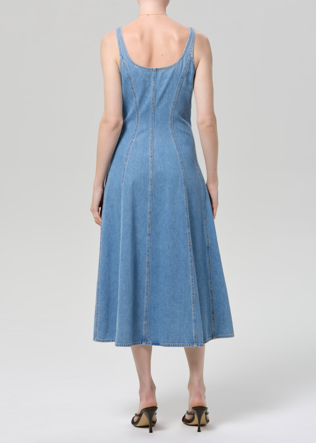 Woman wearing a blue denim dress on a plain background
