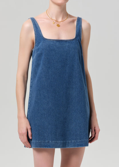 Blue denim dress worn by a person on a gray background