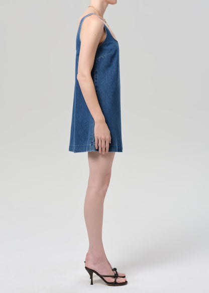 Woman wearing a blue denim dress on a grey background