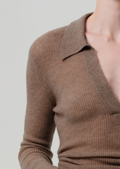 Brown ribbed sweater worn by a person on a plain background