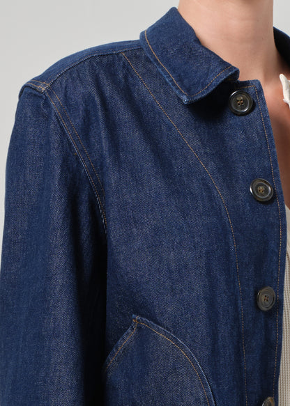 Close-up of a blue denim jacket with buttons on a gray background
