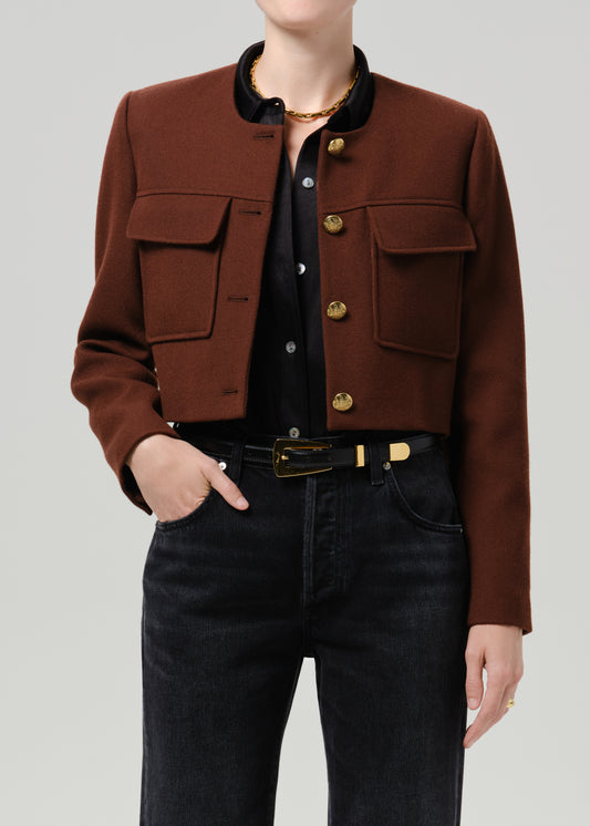 Close-up of a brown tailored cropped jacket on a grey background