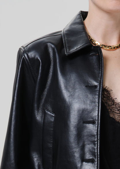 Close-up of a black leather button-up shirt on a grey background.