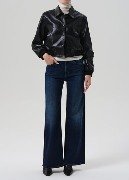 Person wearing a black leather jacket and blue jeans on a white background