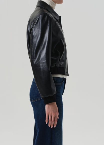 Person wearing a black leather jacket on a light gray background