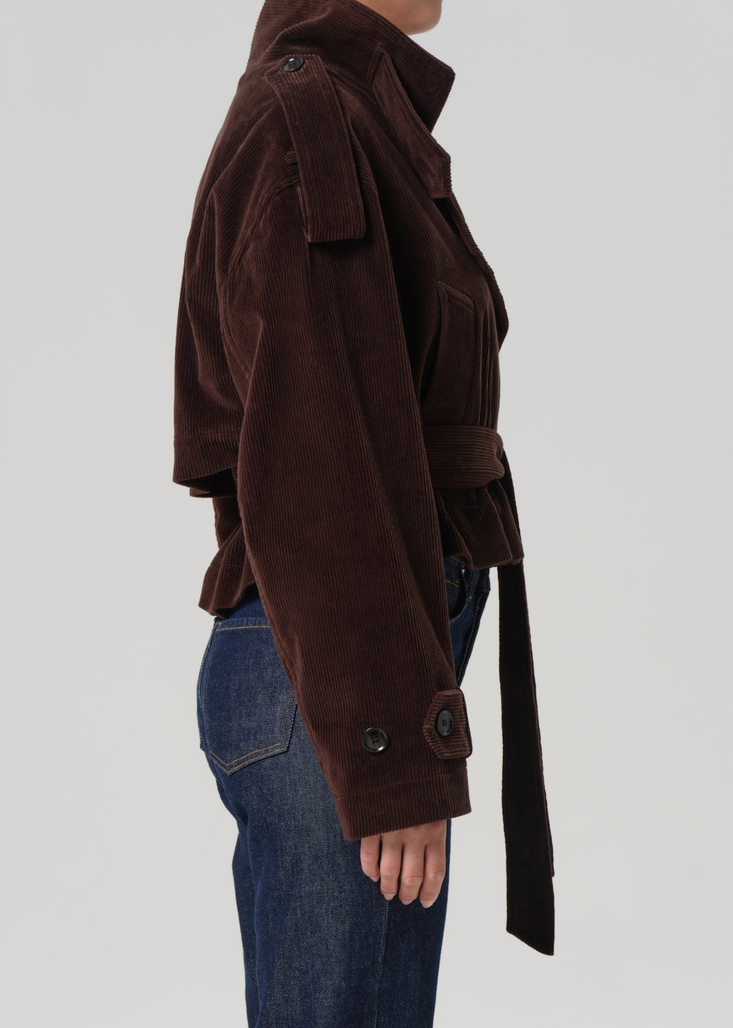 Brown jacket with a belt worn by a person on a white background