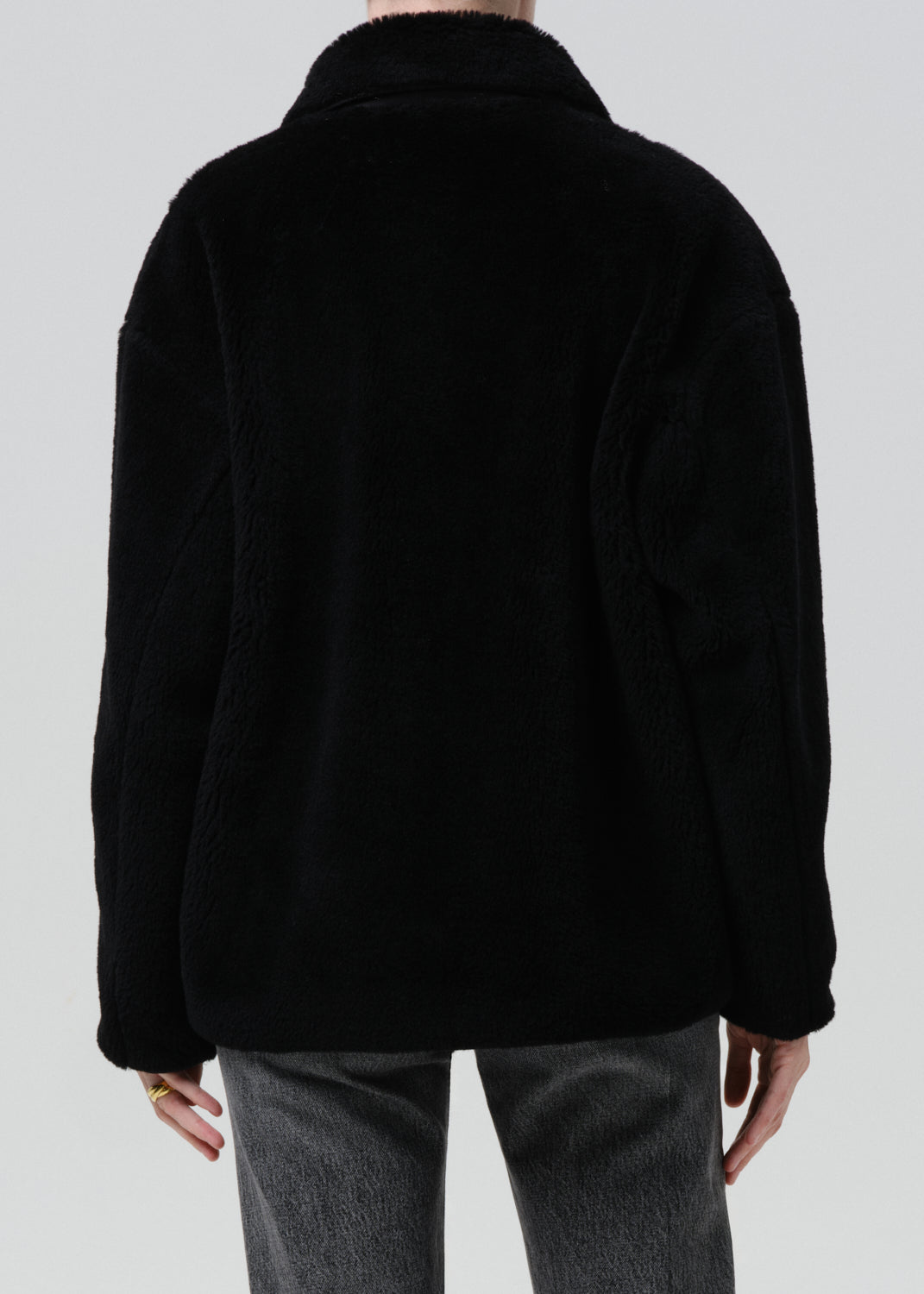 Black jacket worn by a person on a grey background