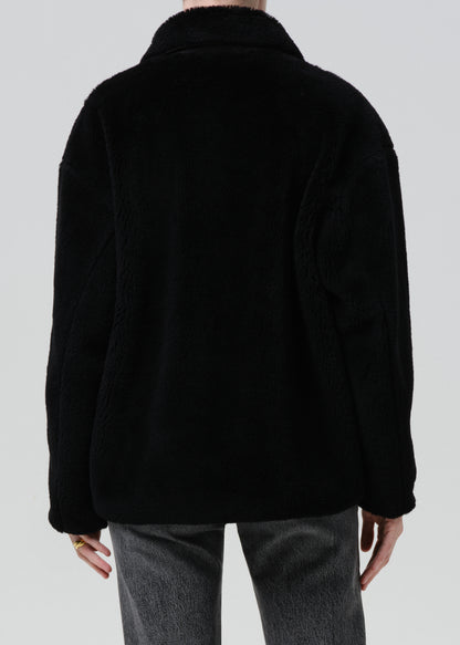 Black jacket worn by a person on a grey background