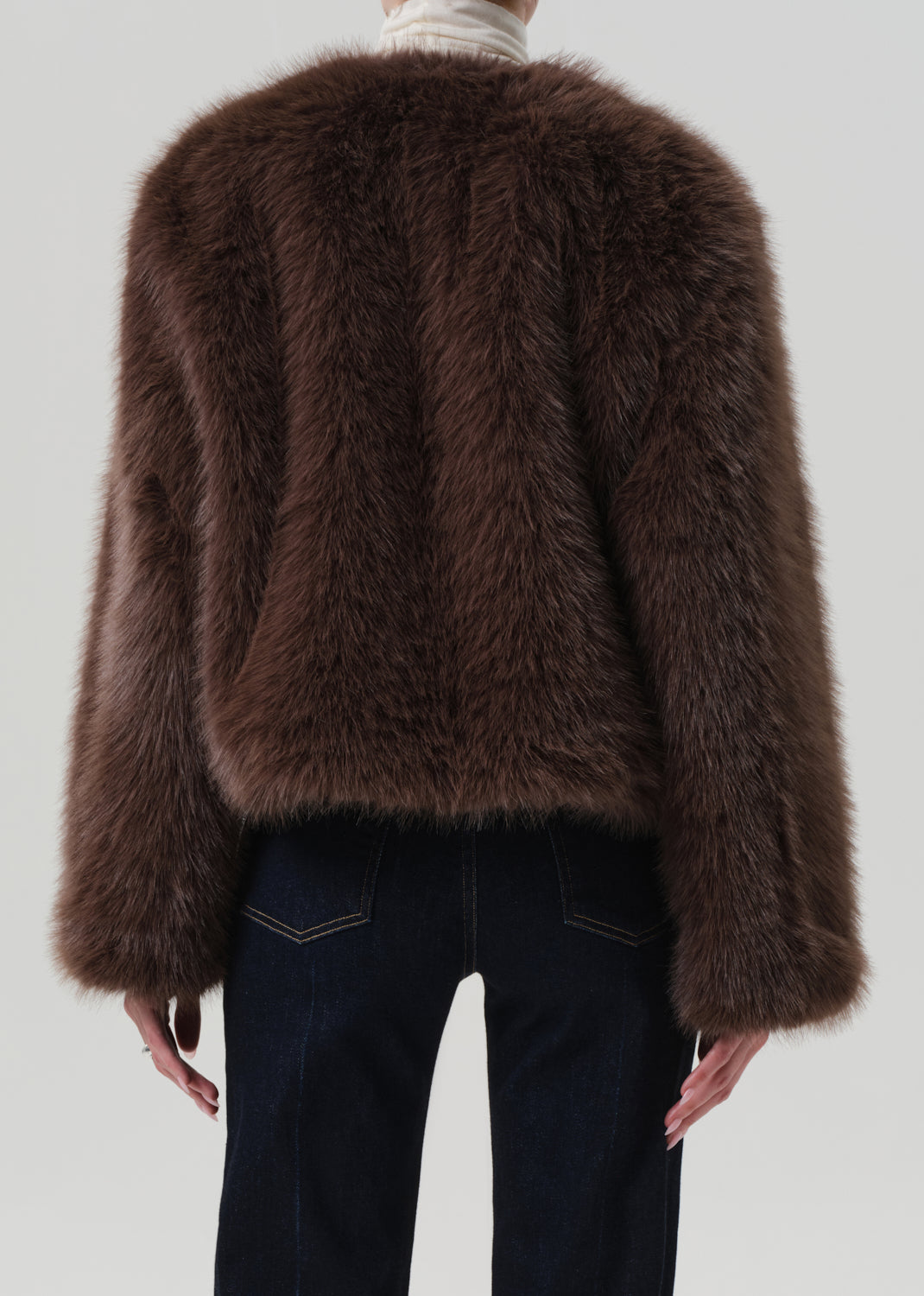 Brown fluffy jacket worn by a person on a plain background