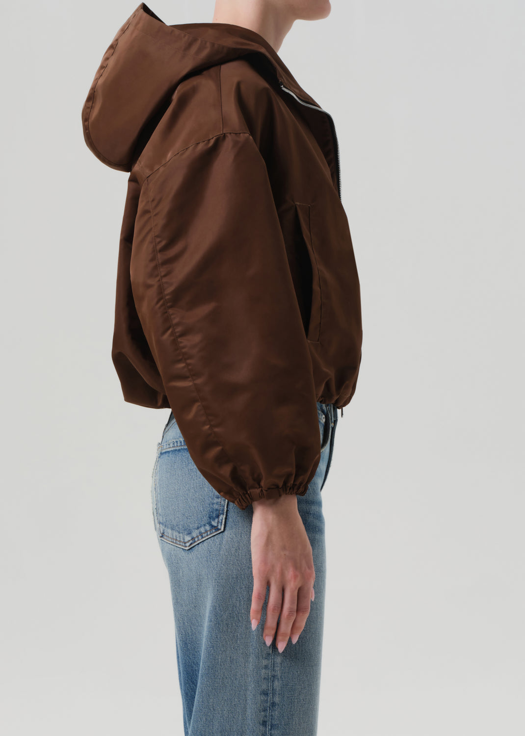 Brown hooded jacket worn by a person on a plain background