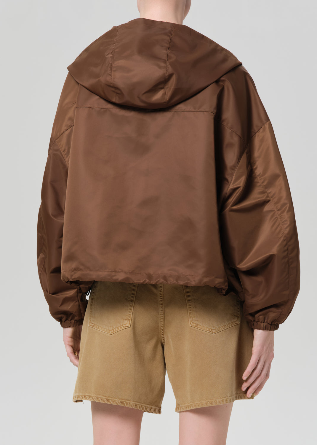 Brown hooded jacket worn by a person on a plain background