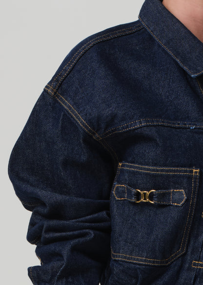 Close-up of a dark blue denim jacket with a pocket on a light gray background