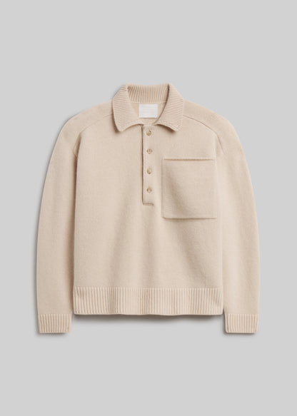 Agatha Rugby in Pillow, featuring a soft cream knit, ribbed collar, four-button placket, front chest pocket, and ribbed cuffs and hem, front view on a grey background.