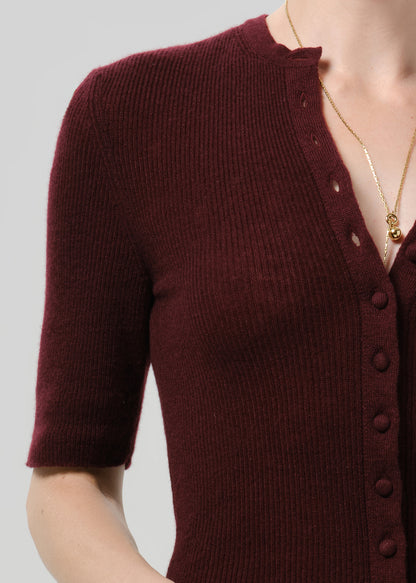 Close up shot of burgundy cardigan on a grey background