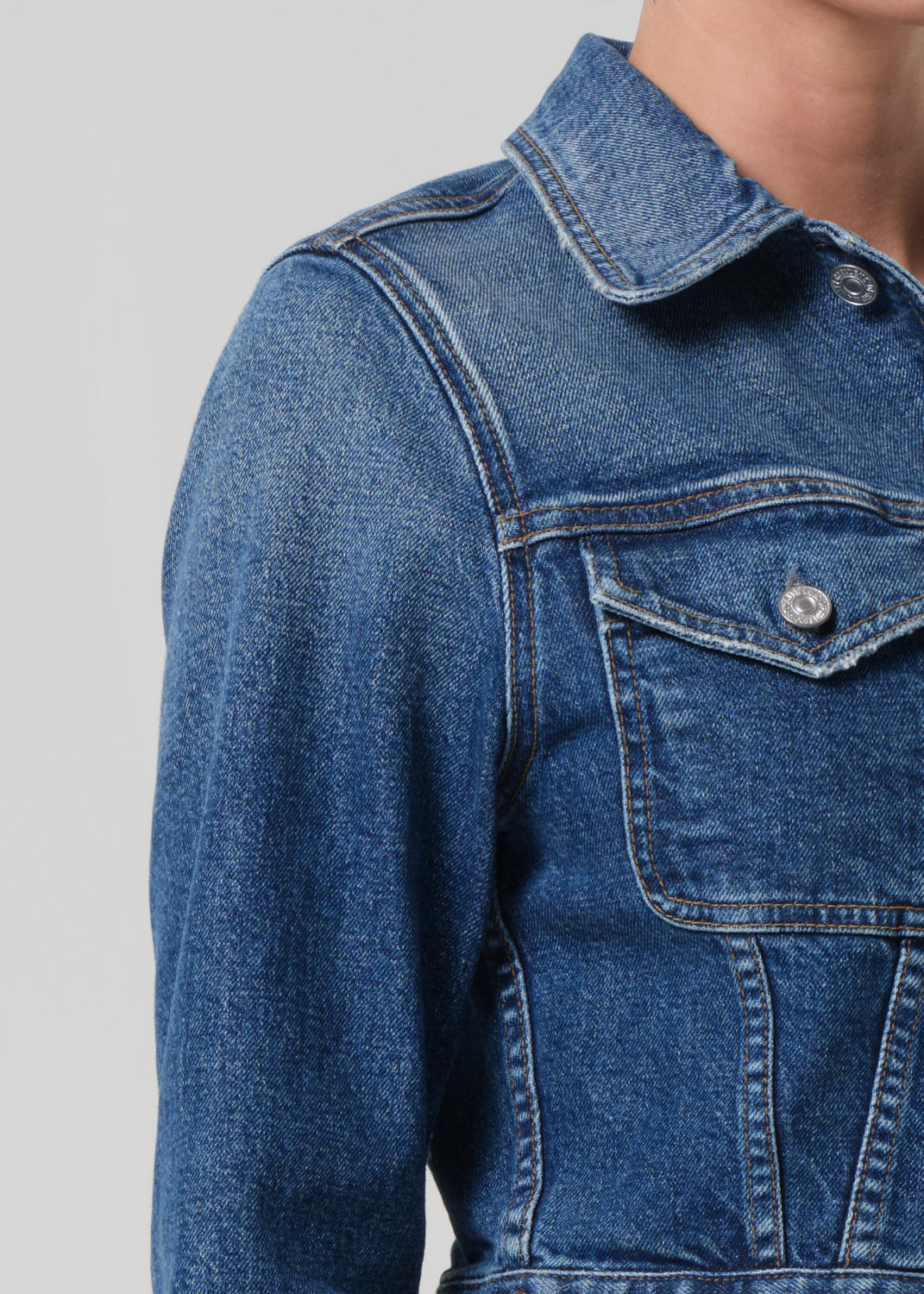Close-up of a blue denim jacket on a plain background