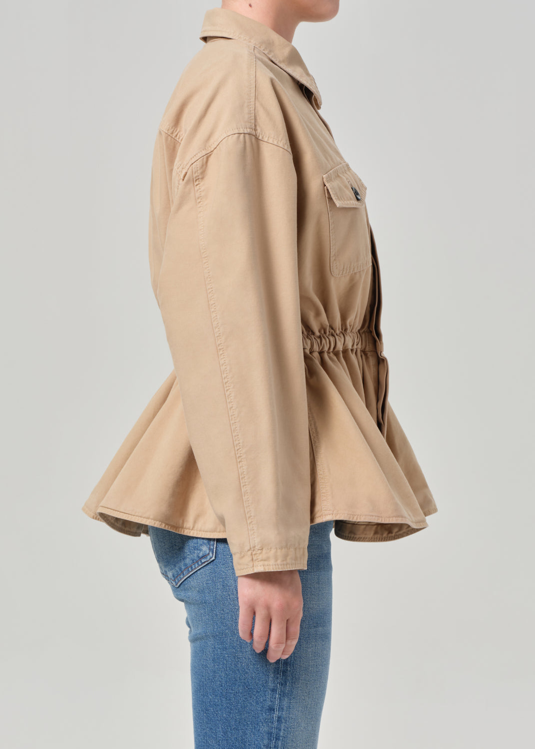 Beige jacket worn by a person on a plain background
