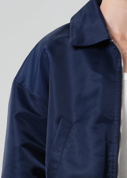 Navy blue jacket with a zipper on a light gray background