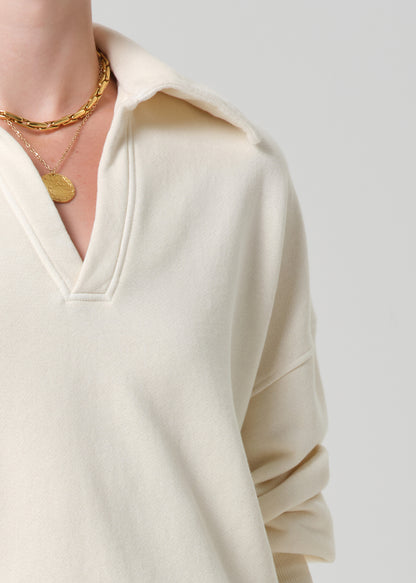 Person wearing a cream-colored sweatshirt on a plain background