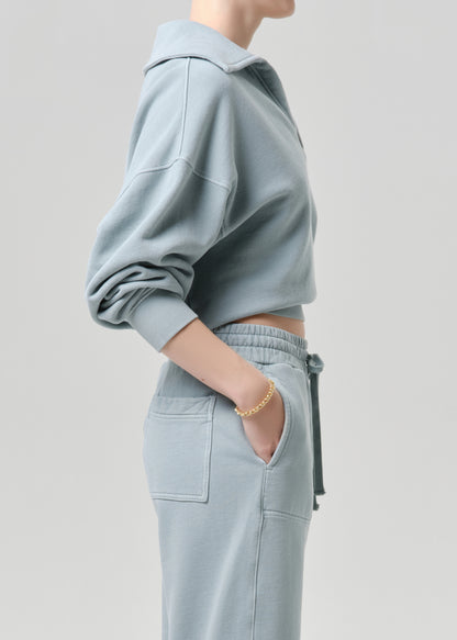 Person wearing a light blue outfit with a grey background