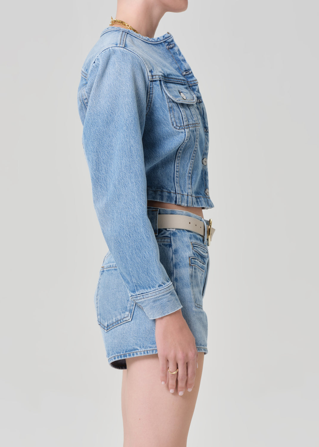 Person wearing a denim jacket with denim shorts 