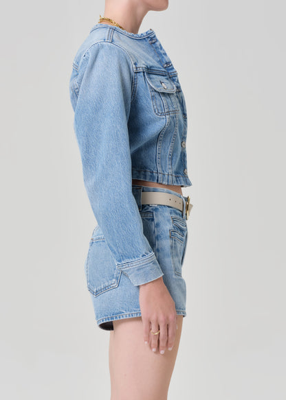 Person wearing a denim jacket with denim shorts 