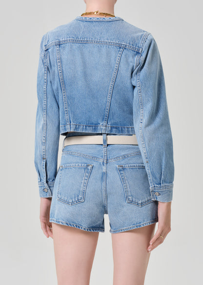 Person wearing a denim jacket with denim shorts 