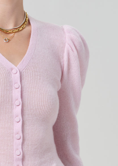 Pink cardigan worn by a person on a light gray background