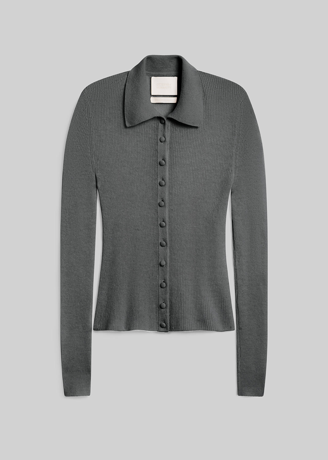 Paloma Cardigan Sweater in Juniper, featuring a fitted silhouette, grey-green ribbed knit, pointed collar, long sleeves, and tonal buttons down the front, front view on a grey background.