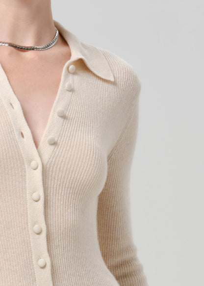 Close up shot of white cardigan on grey background
