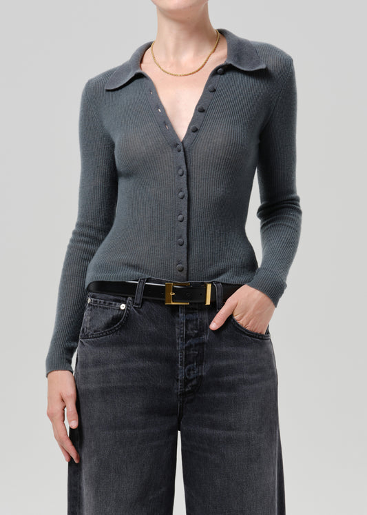Person wearing a charcoal ribbed collared cardigan with black wide leg jeans on a grey background