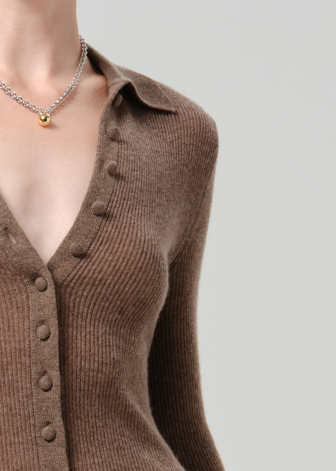 Close up of brown cardigan on grey background