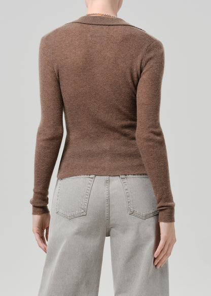 Person wearing a brown cardigan on a grey background