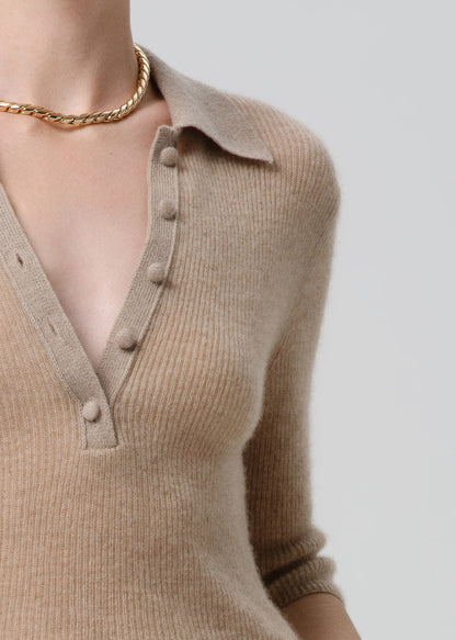 Beige ribbed sweater with button details on a grey background