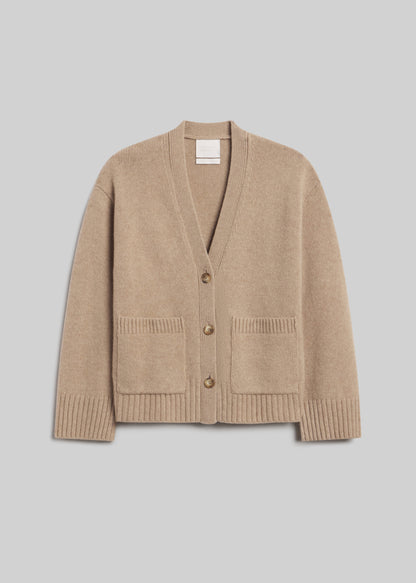 Essential Slouchy Cardigan Sweater in Fawn, featuring a relaxed fit, V-neckline, three-button front closure, two patch pockets, and ribbed cuffs and hem, front view on a grey background.