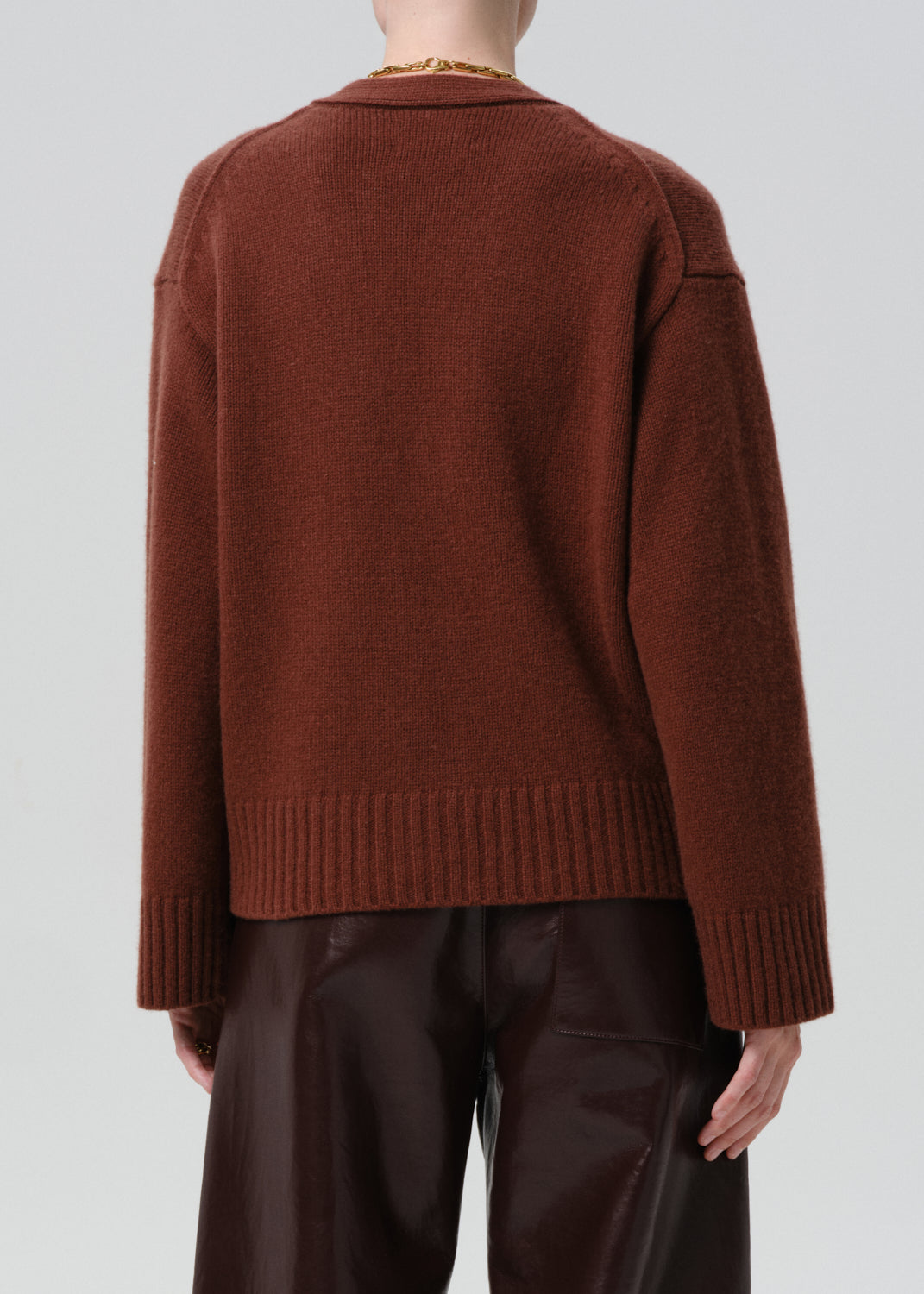 Brown sweater worn by a person on a grey background