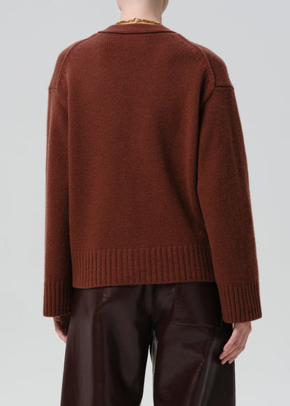 Brown sweater worn by a person on a grey background
