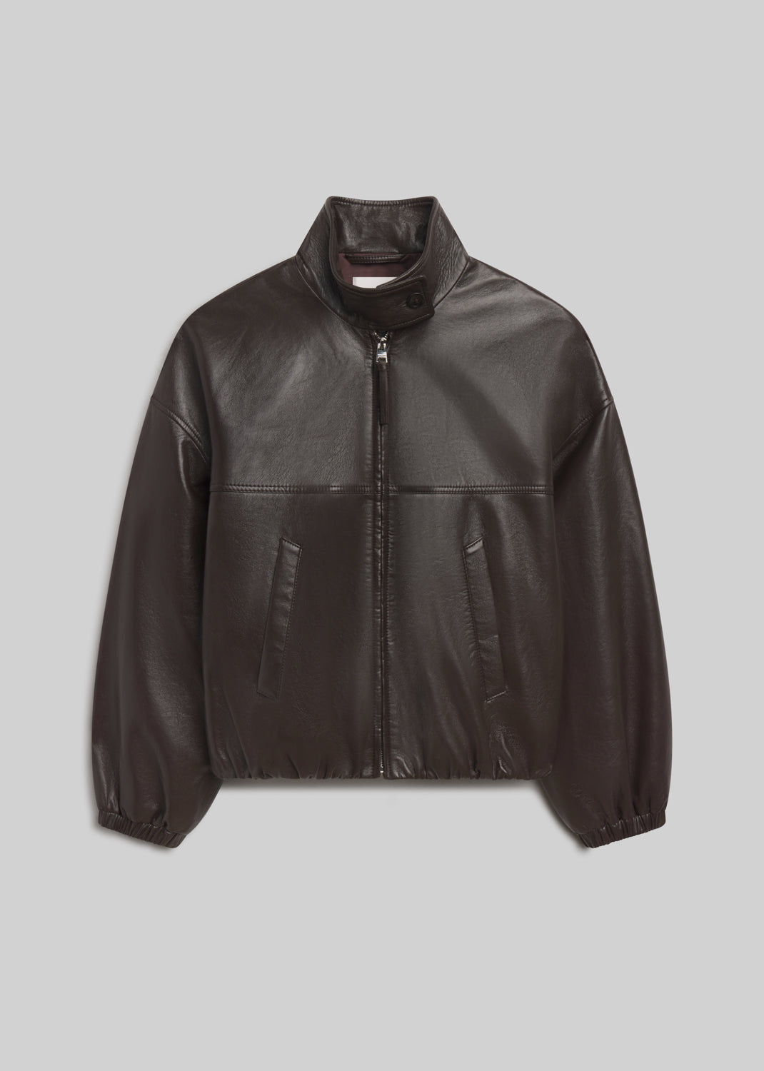 Barracuta Bubble Jacket Leather in dark chocolate brown leather, featuring a relaxed silhouette, stand collar with button closure, front zipper, side pockets, and elasticated cuffs and hem, front view on a grey background.