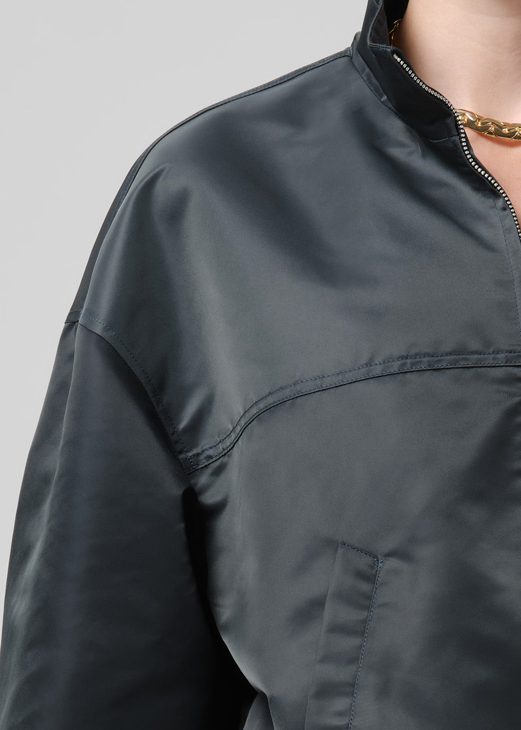Person wearing dark green nylon jacket paired with black pants