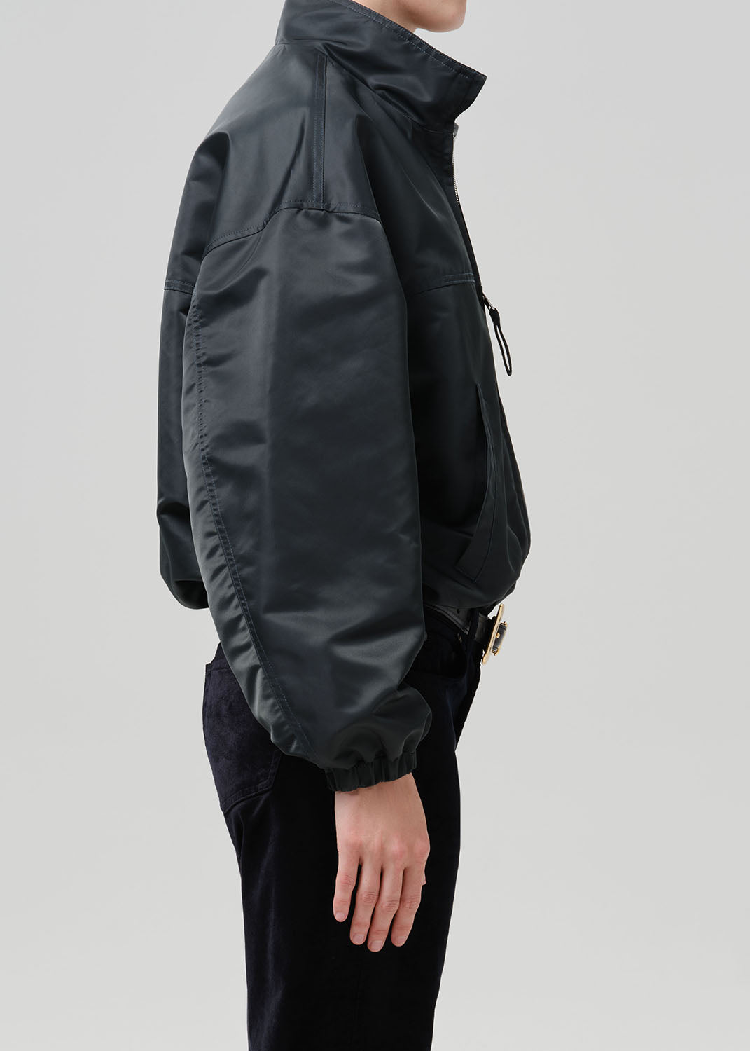 Person wearing dark green nylon jacket paired with black pants
