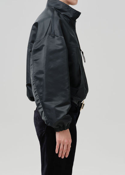Person wearing dark green nylon jacket paired with black pants