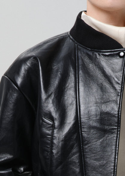 Close-up of a black leather jacket with a grey  background