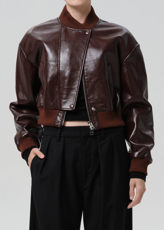 Dark red leather jacket worn by a person on a grey background