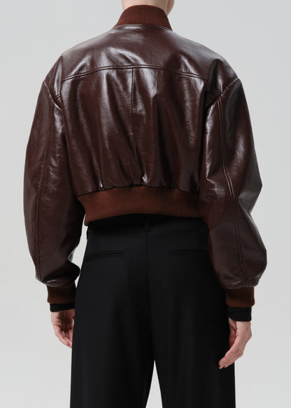 Dark red leather jacket worn by a person on a grey background
