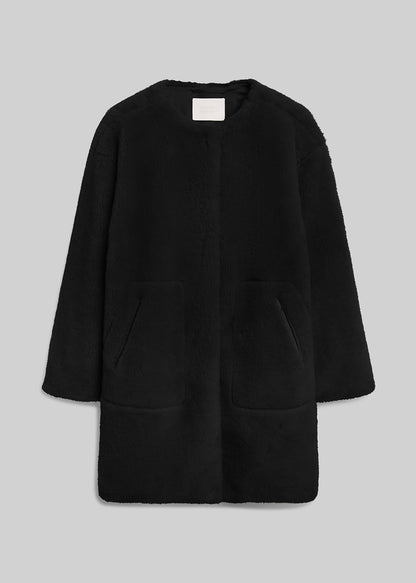 Black long sherpa coat with front pockets on grey background