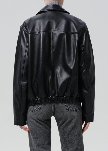 Black leather jacket worn by a person on a grey background