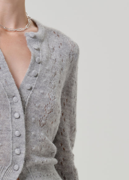 Close-up of a grey button-front cardigan on a grey background.